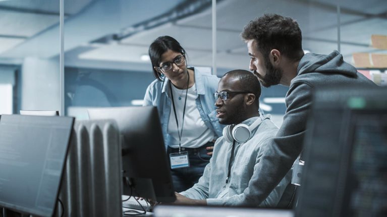 People discussing in front of a computer screen