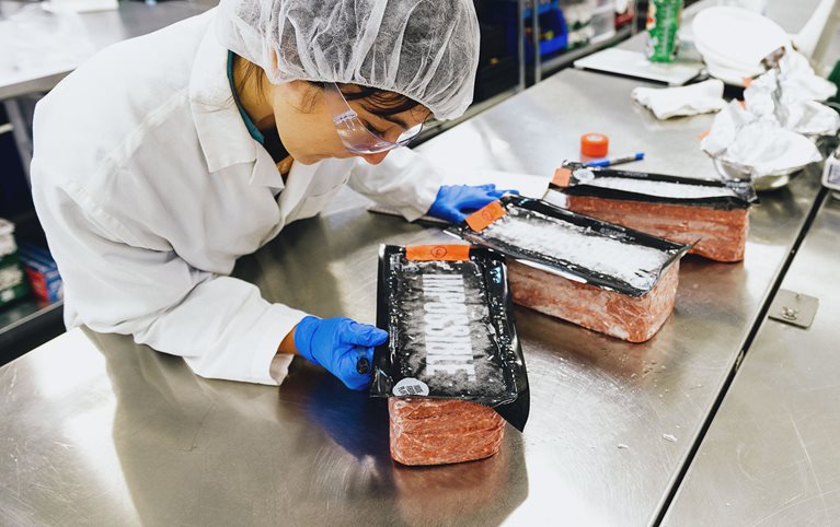 A scientist at Impossible’s Silicon Valley lab inspects the company’s product, which is shipped to distributors and restaurants in the form of five-pound bricks.