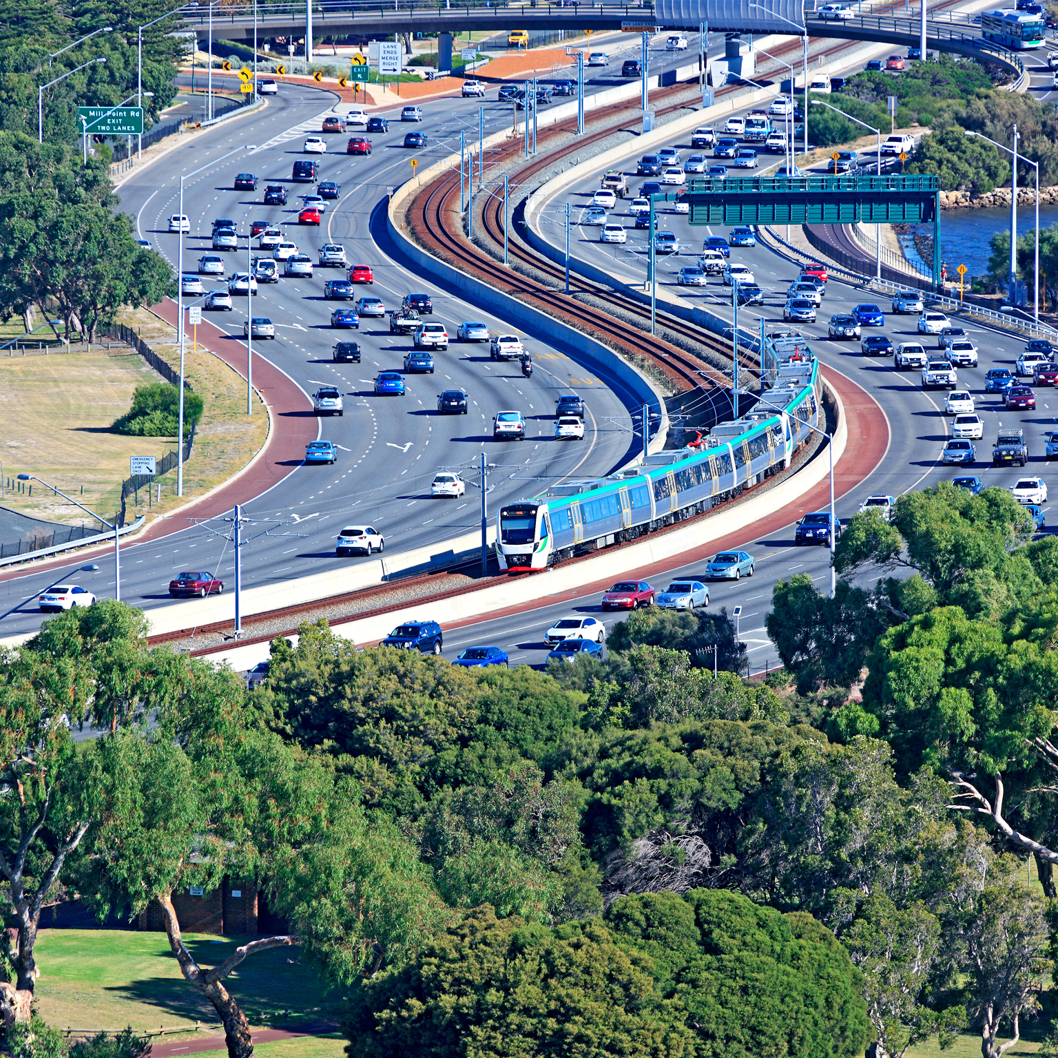 City transport: electric train travels down middle of busy freeway