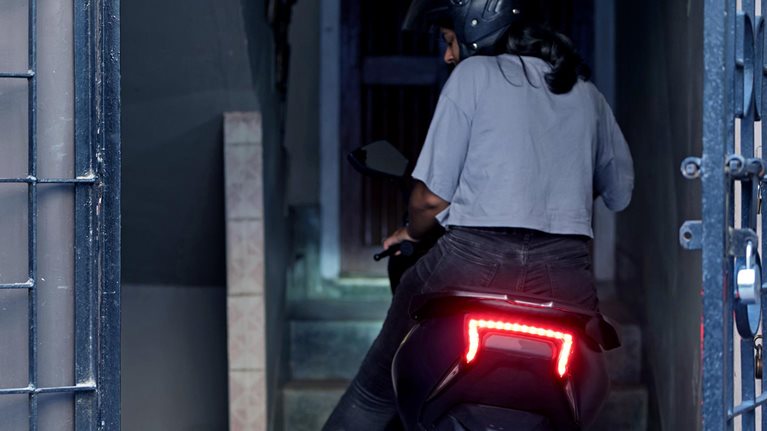 Young Woman parking her electric scooter. - stock photo