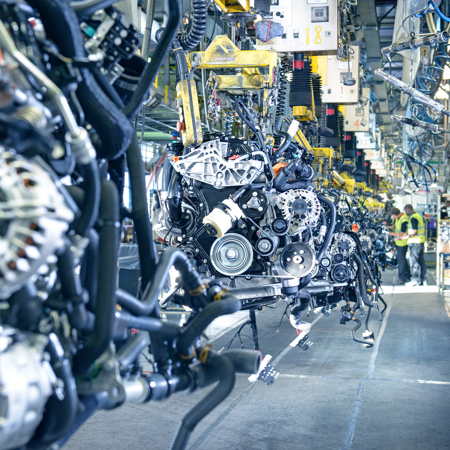 Workers on engine production line in car factory 