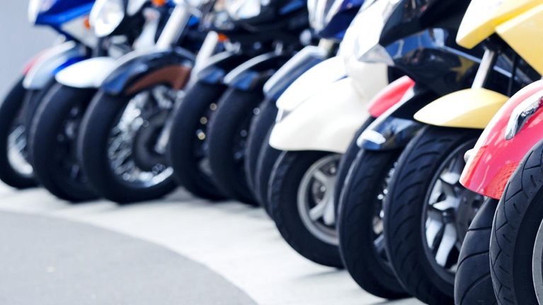 A row of motor scooters standing on the street