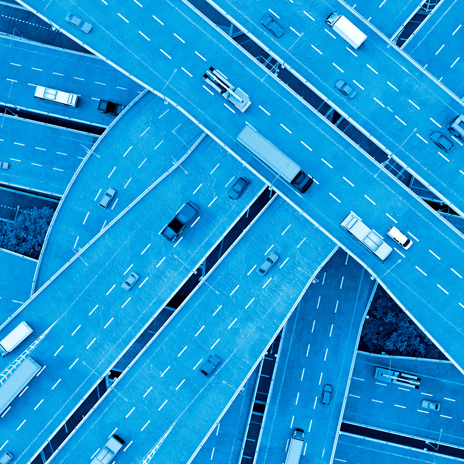 Cars, busses and trucks drive on multiple-lane highways.