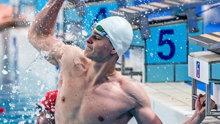 Male swimmer punching the air during swimming competition.