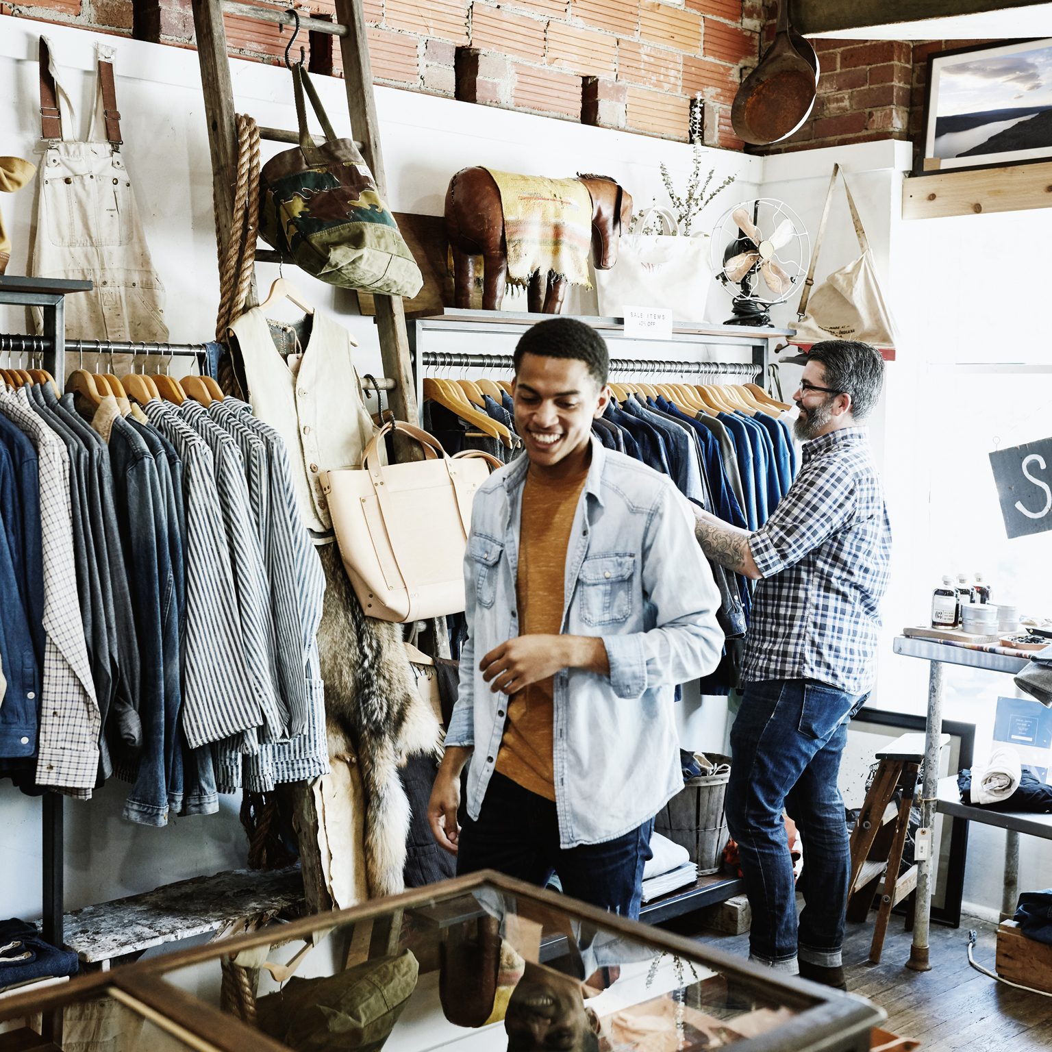 Smiling customers shopping in men's boutique.