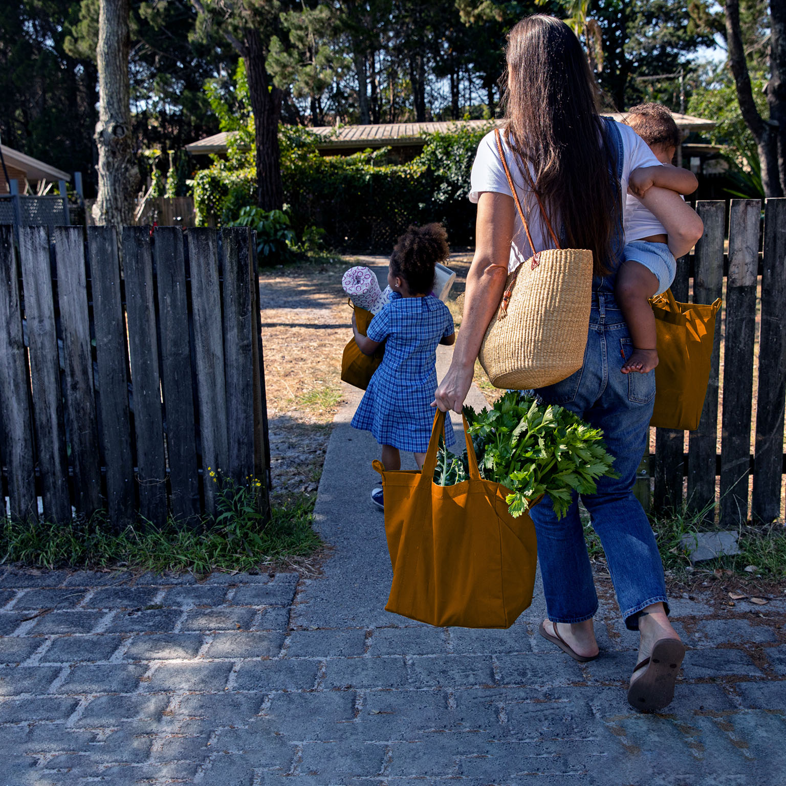 Young Australian family carries the shopping in together and hugs after being at school and work
