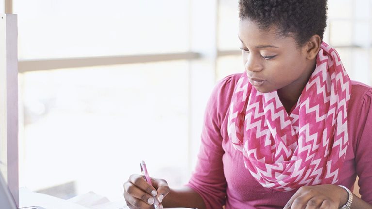 photo woman with open book taking online course on laptop