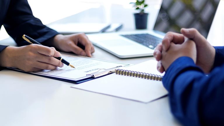 The manager is reading the resume and is interviewing the new employee. Negotiating business and signing a contract. Lawyer and legal advisor. - stock photo