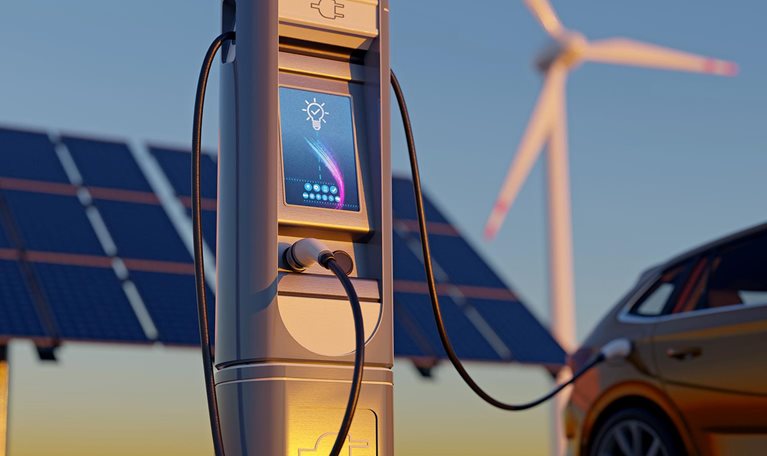 Electric car charging with wind turbines and solar panel - stock photo