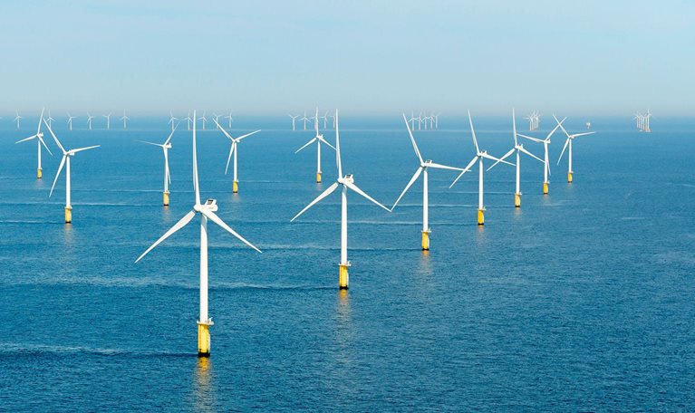 Windmills standing in a waterbody.