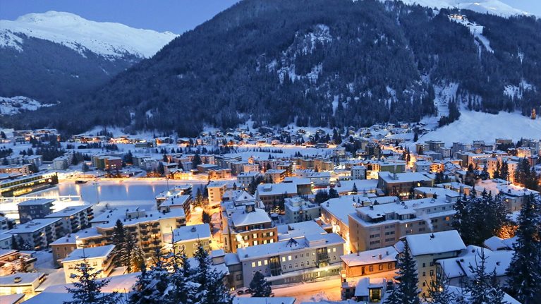 Snow-covered city at the foot of mountains