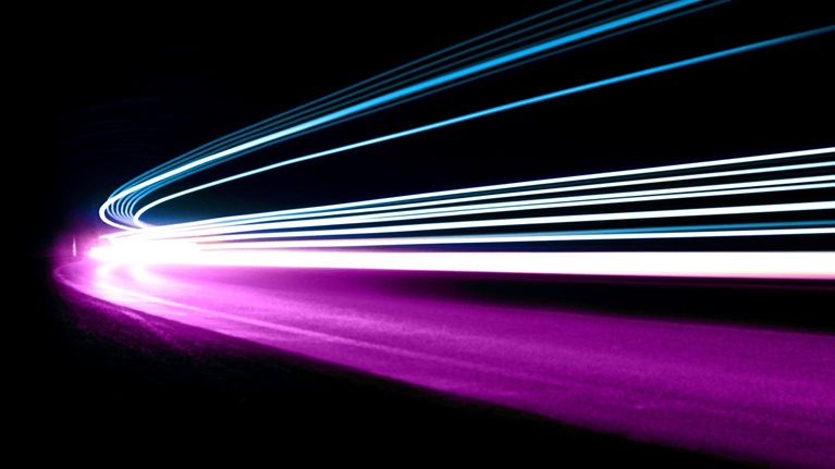 The blue, white, and purple light trails move in unison, giving the impression of coordinated movement and speed.