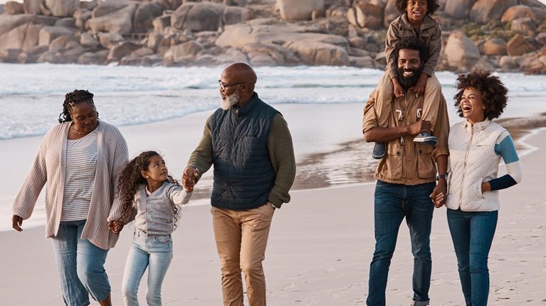 photo three generational family walking on beach