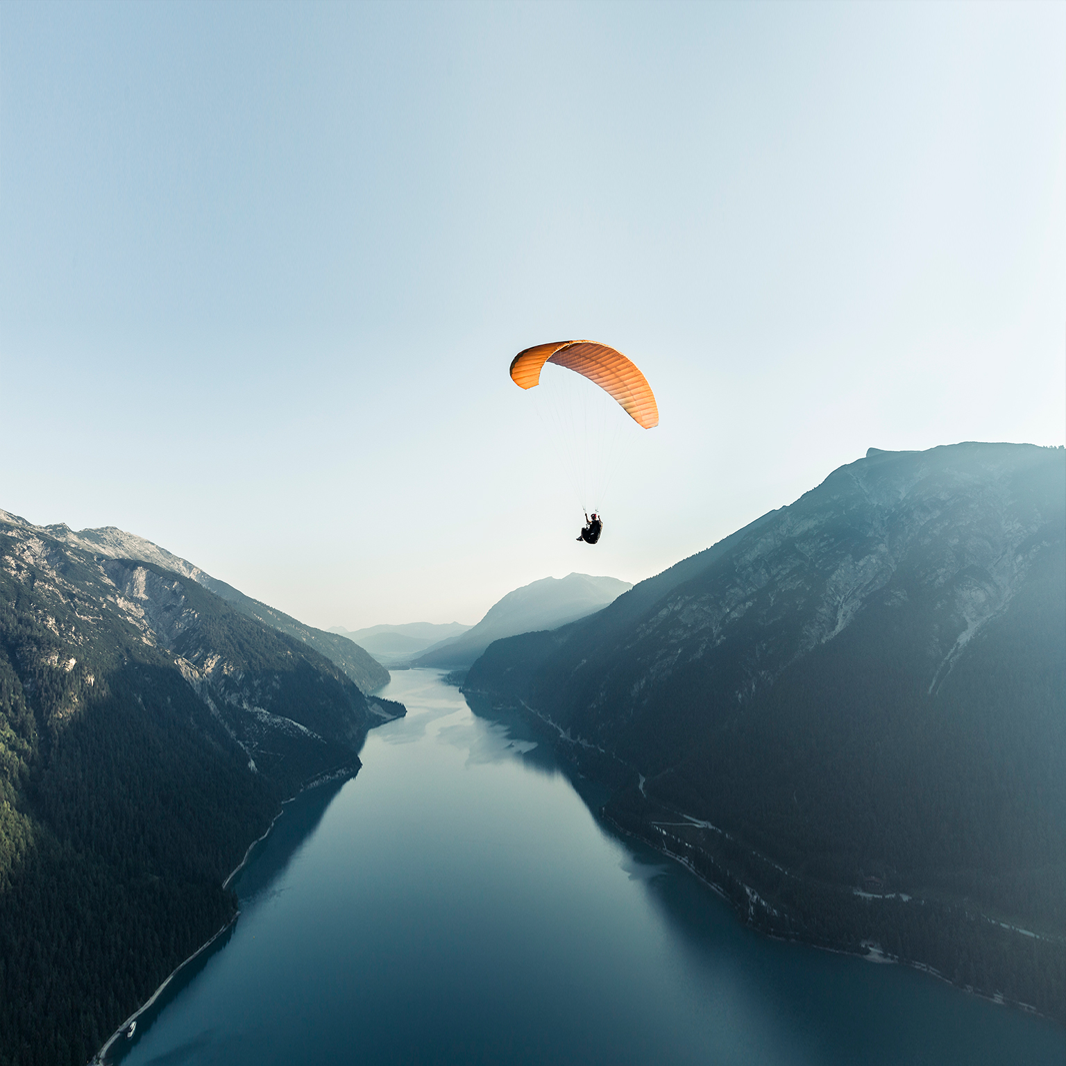 Austria, Tyrol, Paraglider over lake Achensee in the early morning - stock photo