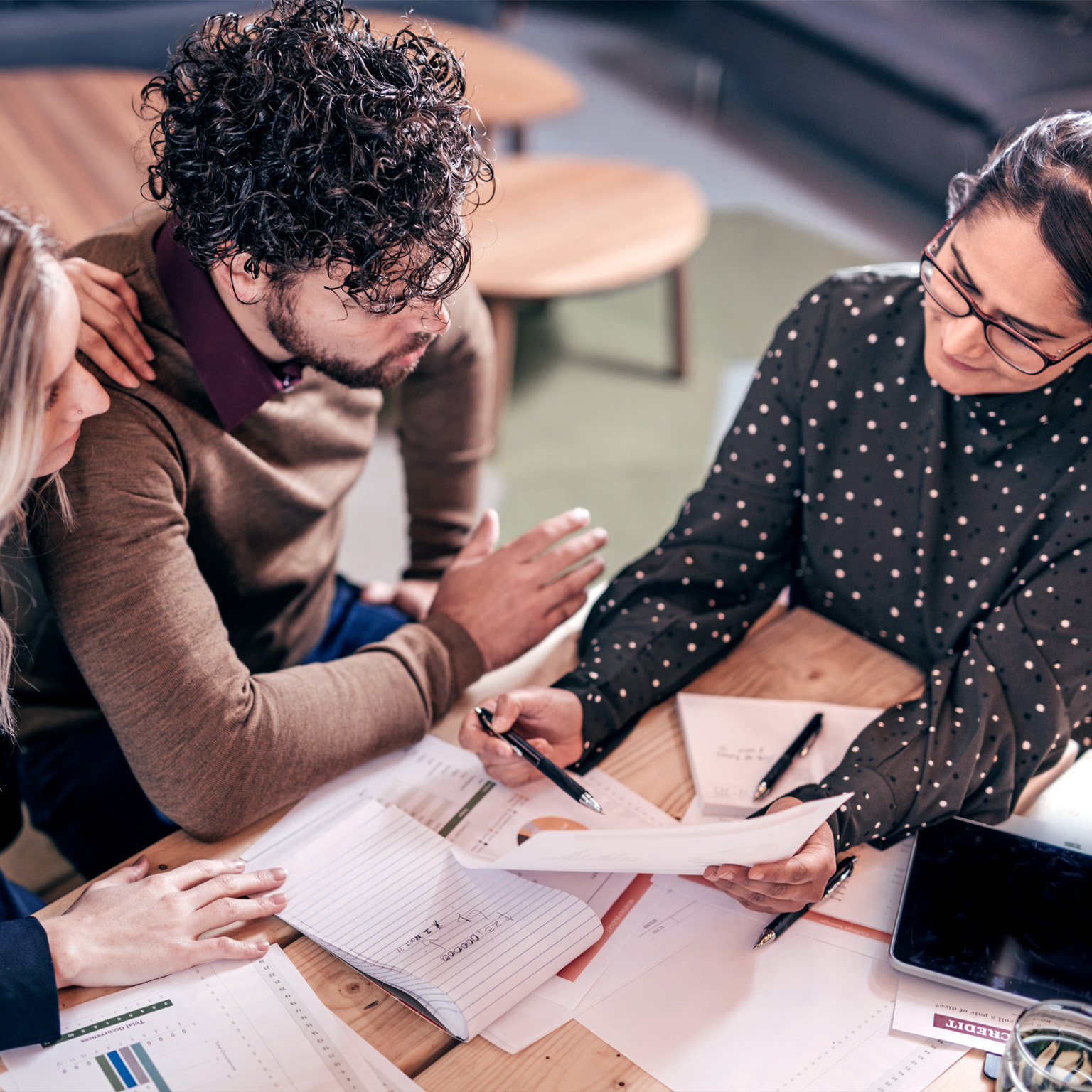 Overhead shot of couple sitting at table with female insurance agent