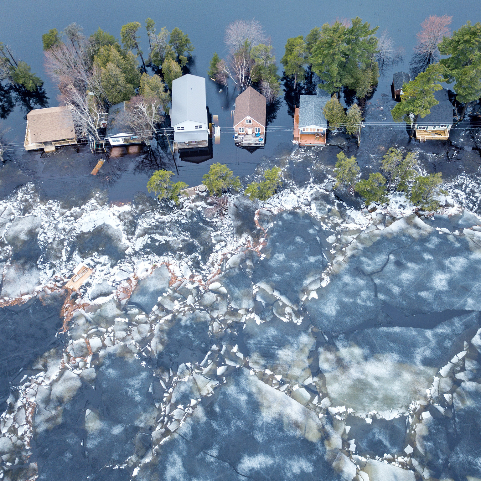 Huge chunks of ice propelled by wind and flood waters threaten cottages on Grand Lake, New Brunswick, Canada.