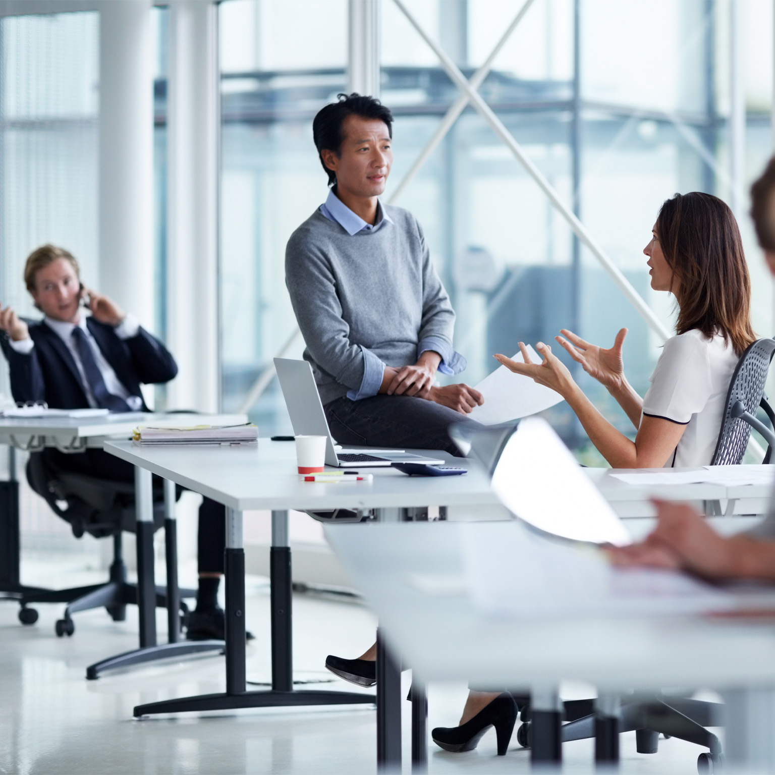photo workers talking in small groups in conference room