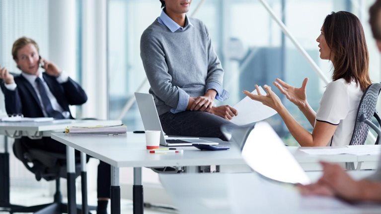 photo workers talking in small groups in conference room