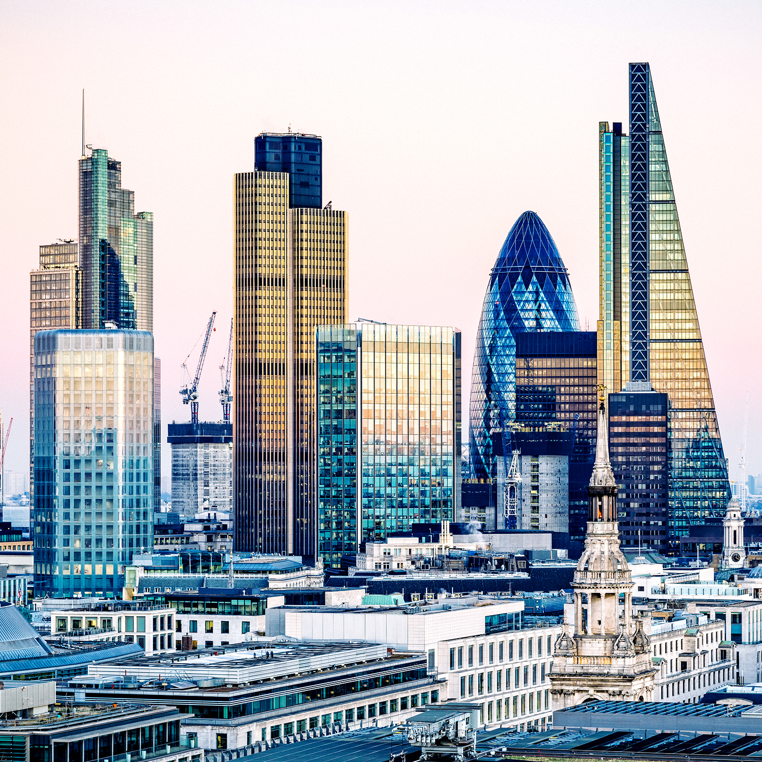 Sunset view of London's financial district, including The Gherkin and The Shard.