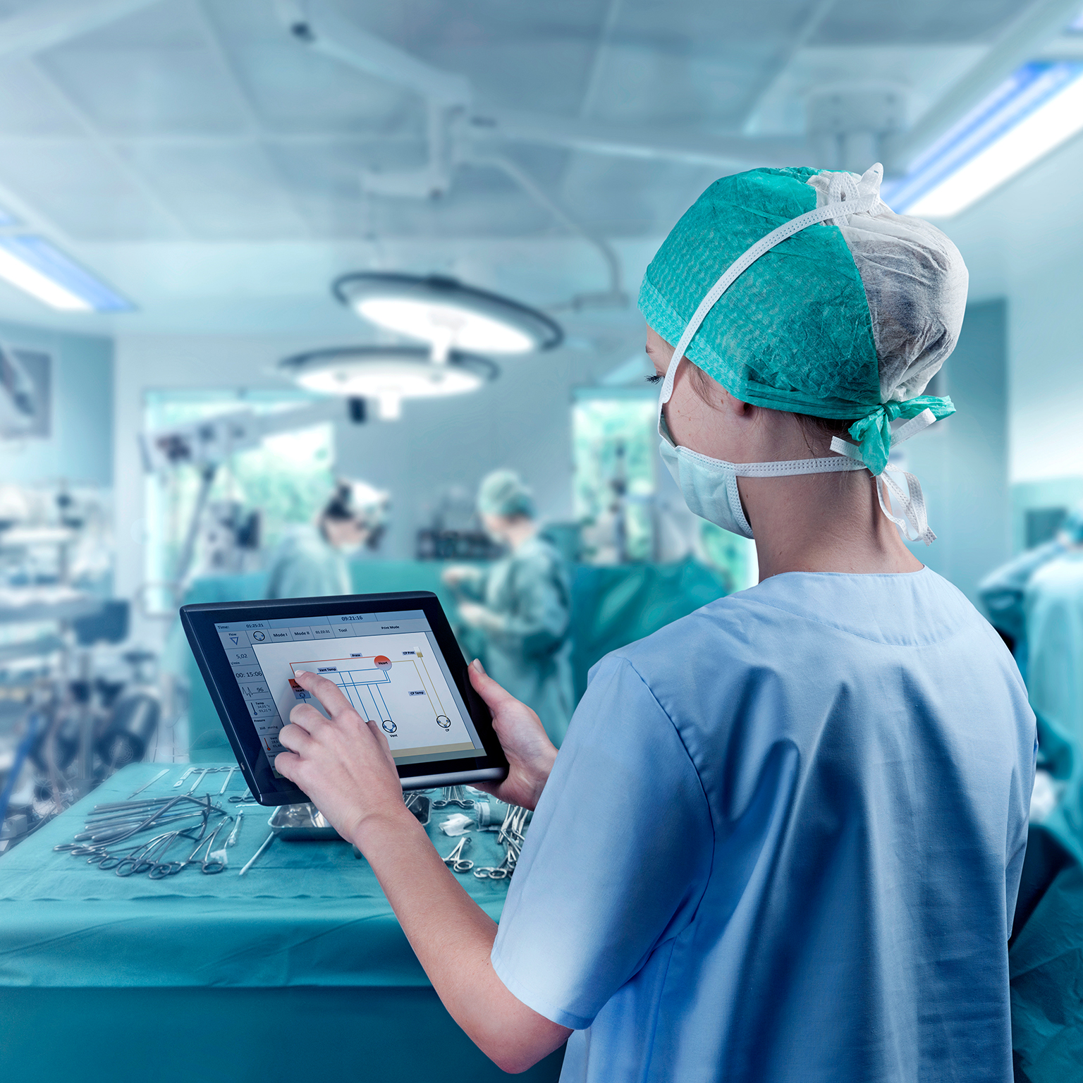 Female surgeon using digital tablet to command artificial heart in operation room.