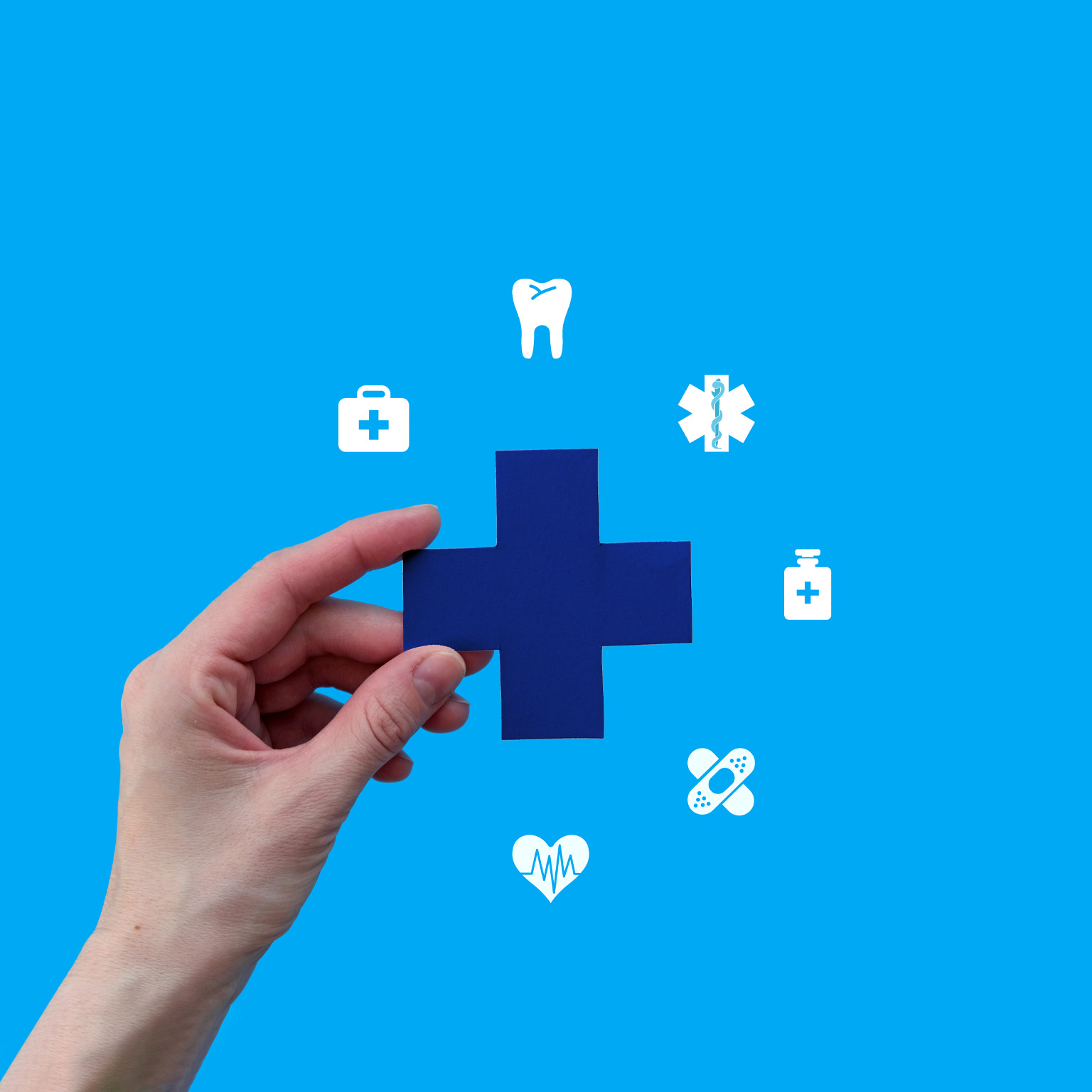 A hand holds a blue medical cross against a bright blue background. Surrounding the cross are various white medical icons, symbolizing comprehensive healthcare services. 