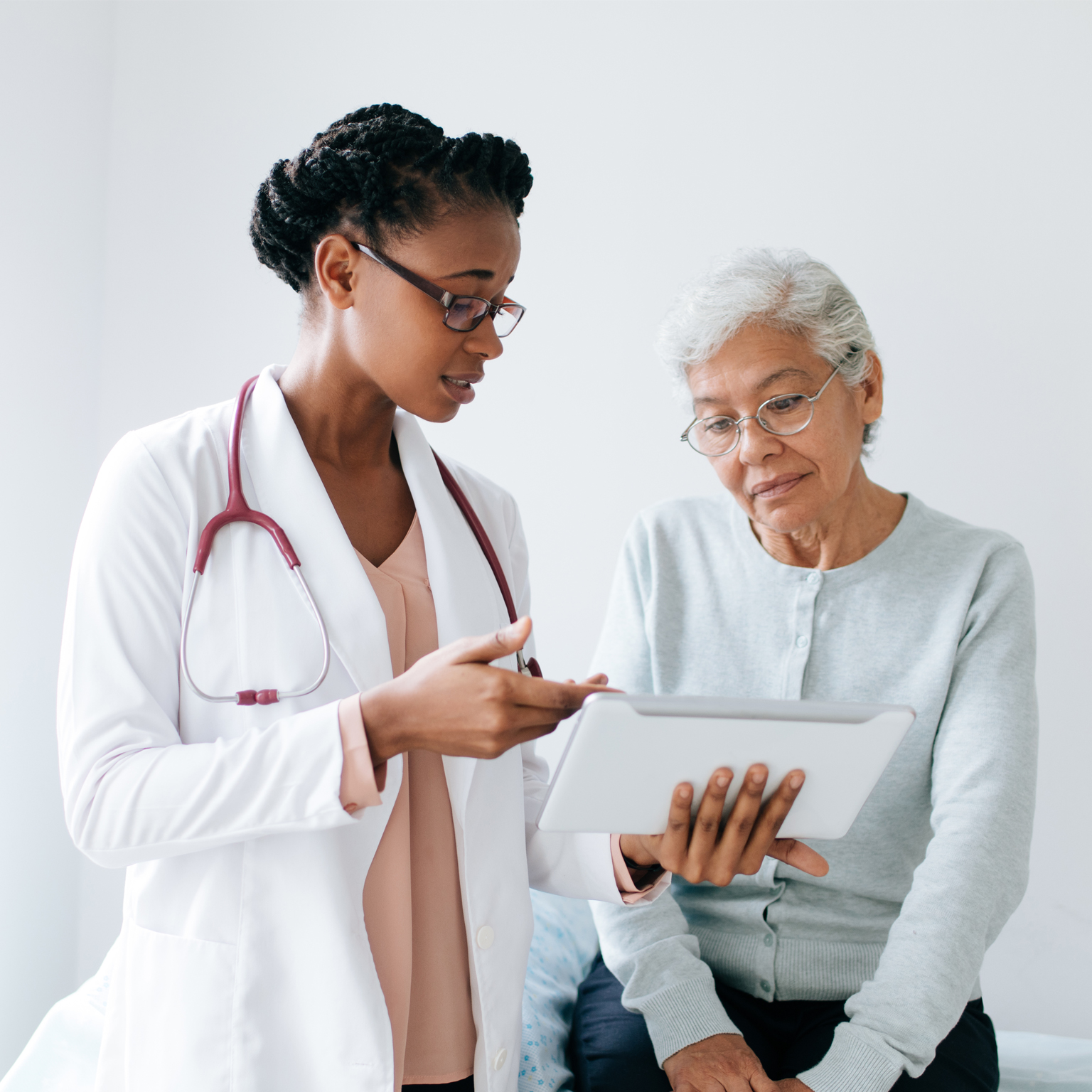 doctor showing woman results on tablet - stock photo