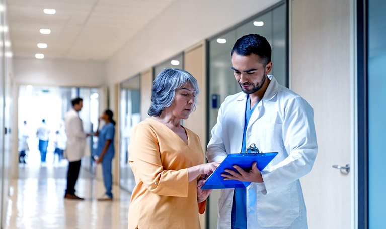 Latin American doctor explaining the test results to a senior woman at the hospital