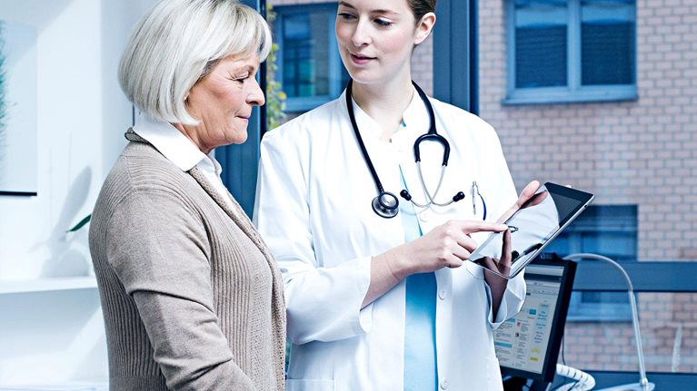 Doctor showing patient results on digital tablet
