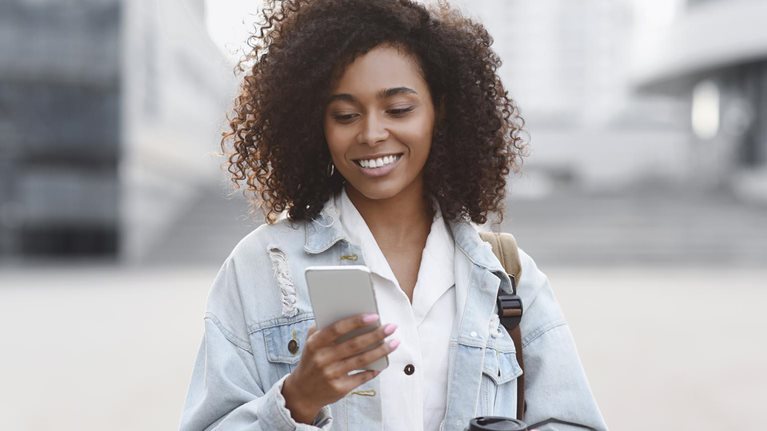 Young woman using smart phone on a city street