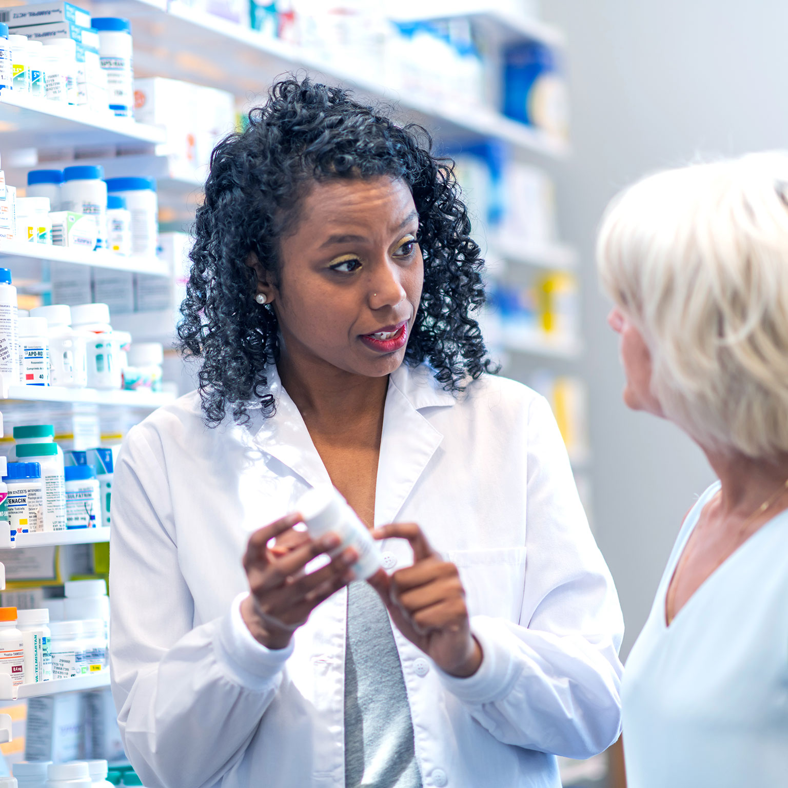 Female pharmacist assisting woman in pharmacy