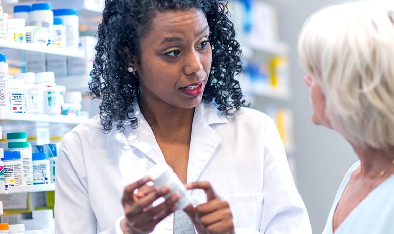 Female pharmacist assisting woman in pharmacy