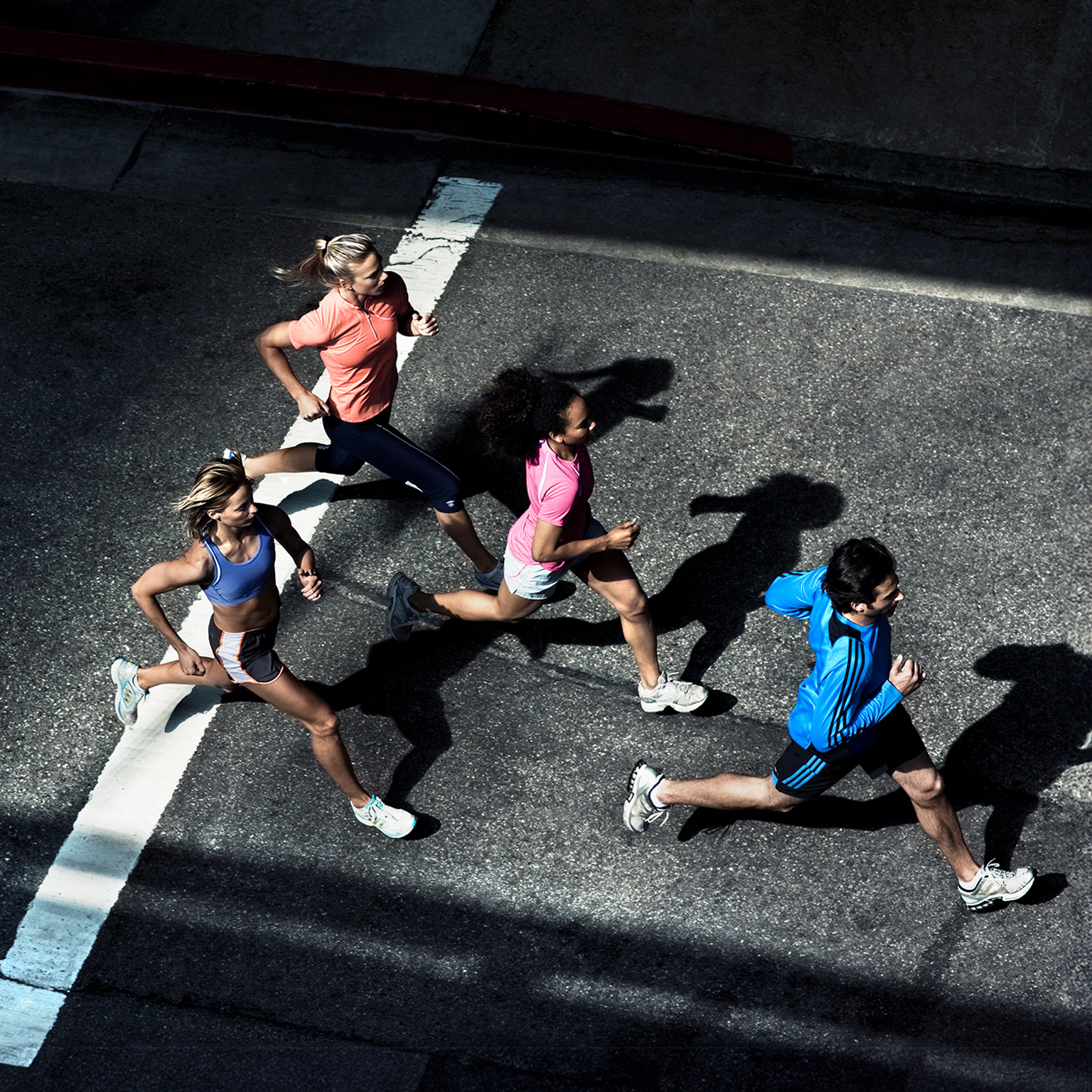 Overhead shot of urban runners going down street. - stock photo
