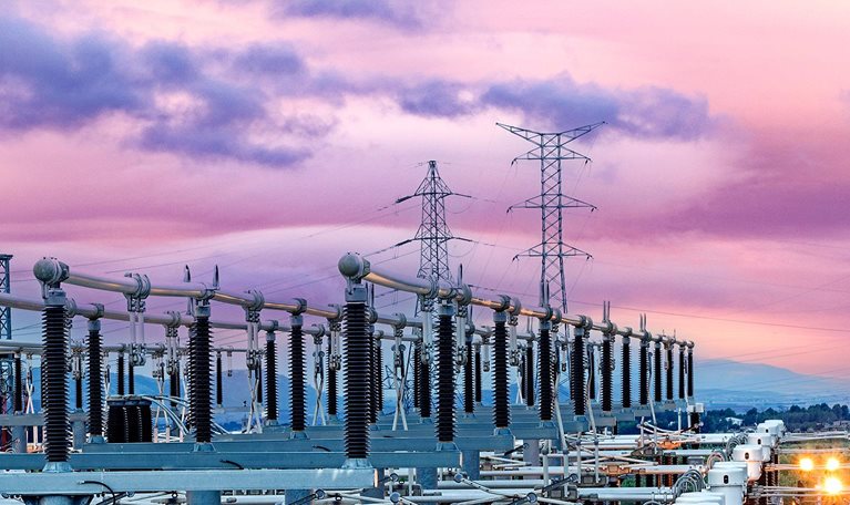 General view of an energy distribution power plant at dusk with the lights on