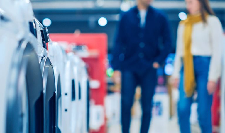 Customers explore modern laundry solutions in a retail shop.