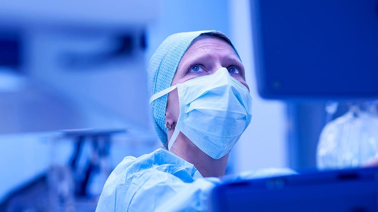 Anesthetist checking parameters gaz and bloodstream of external heart on monitor during open heart surgery.