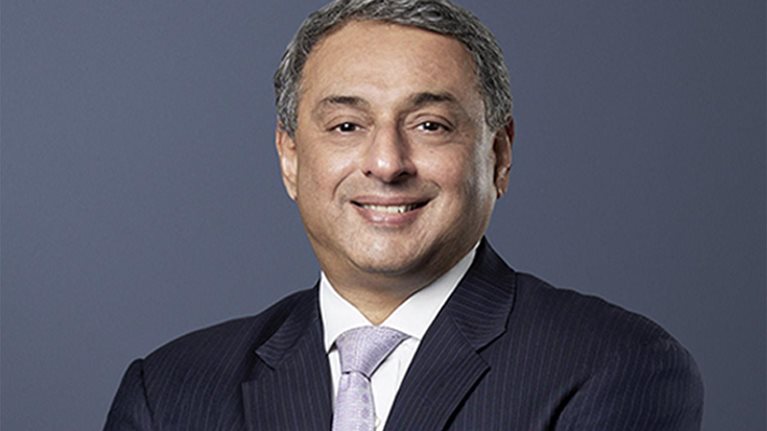 T. V. Narendran, CEO of Tata Steel, stands with a gentle smile, dressed in a dark suit and arms folded across his chest.