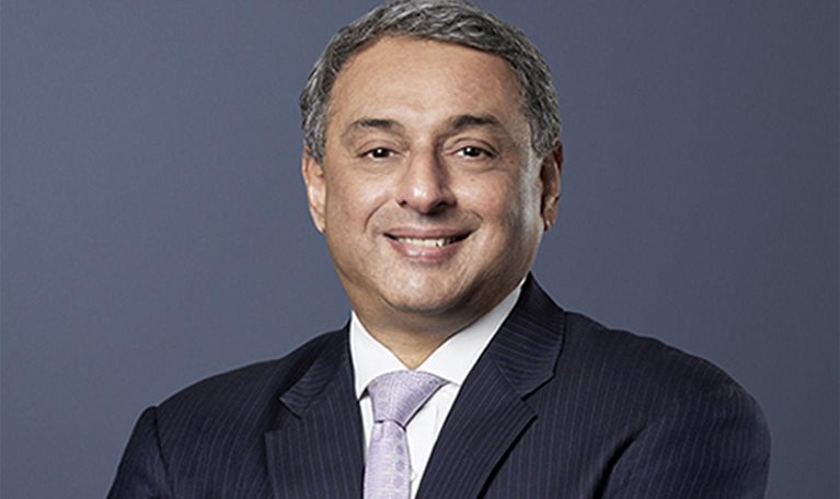 T. V. Narendran, CEO of Tata Steel, stands with a gentle smile, dressed in a dark suit and arms folded across his chest.