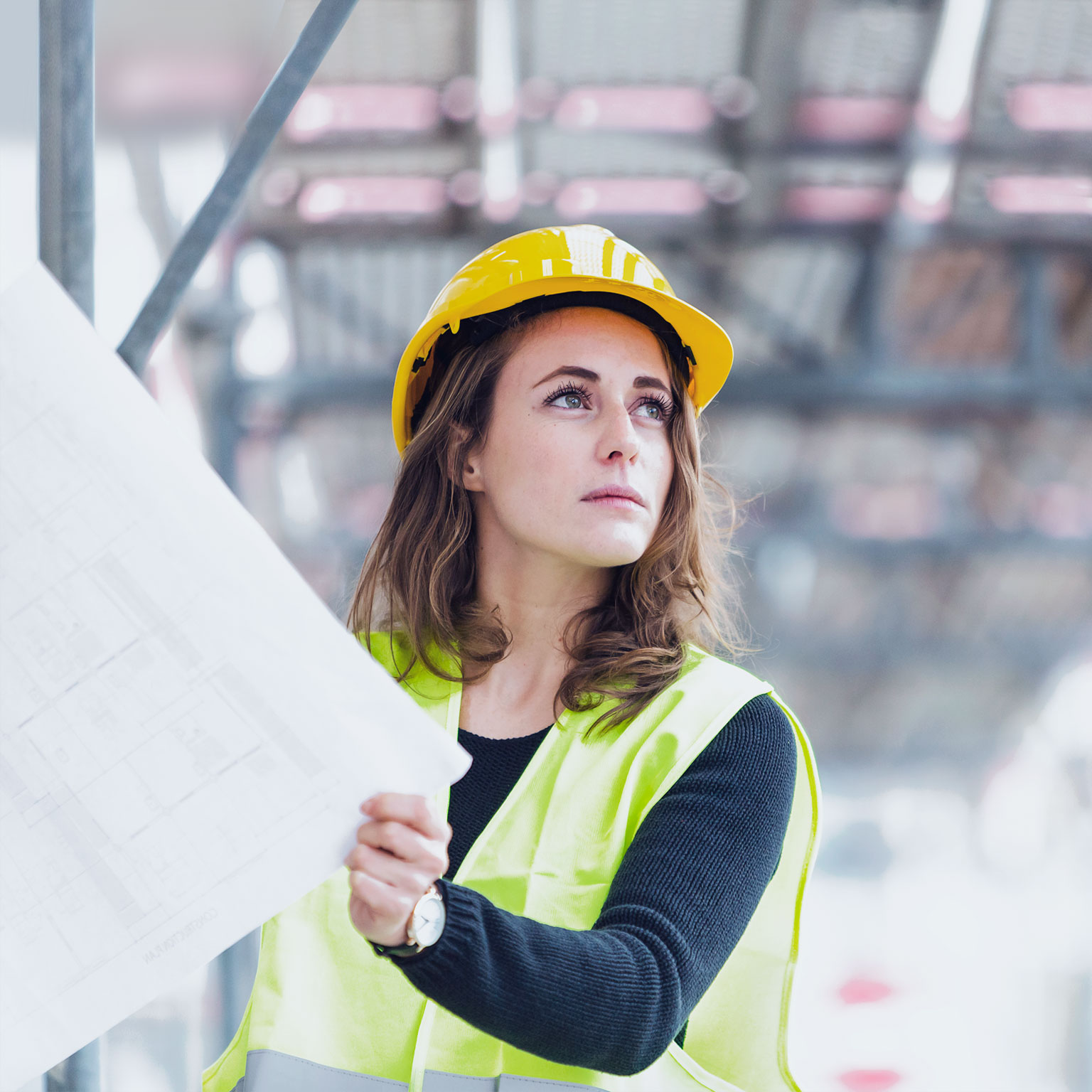 A female construction worker holds plans
