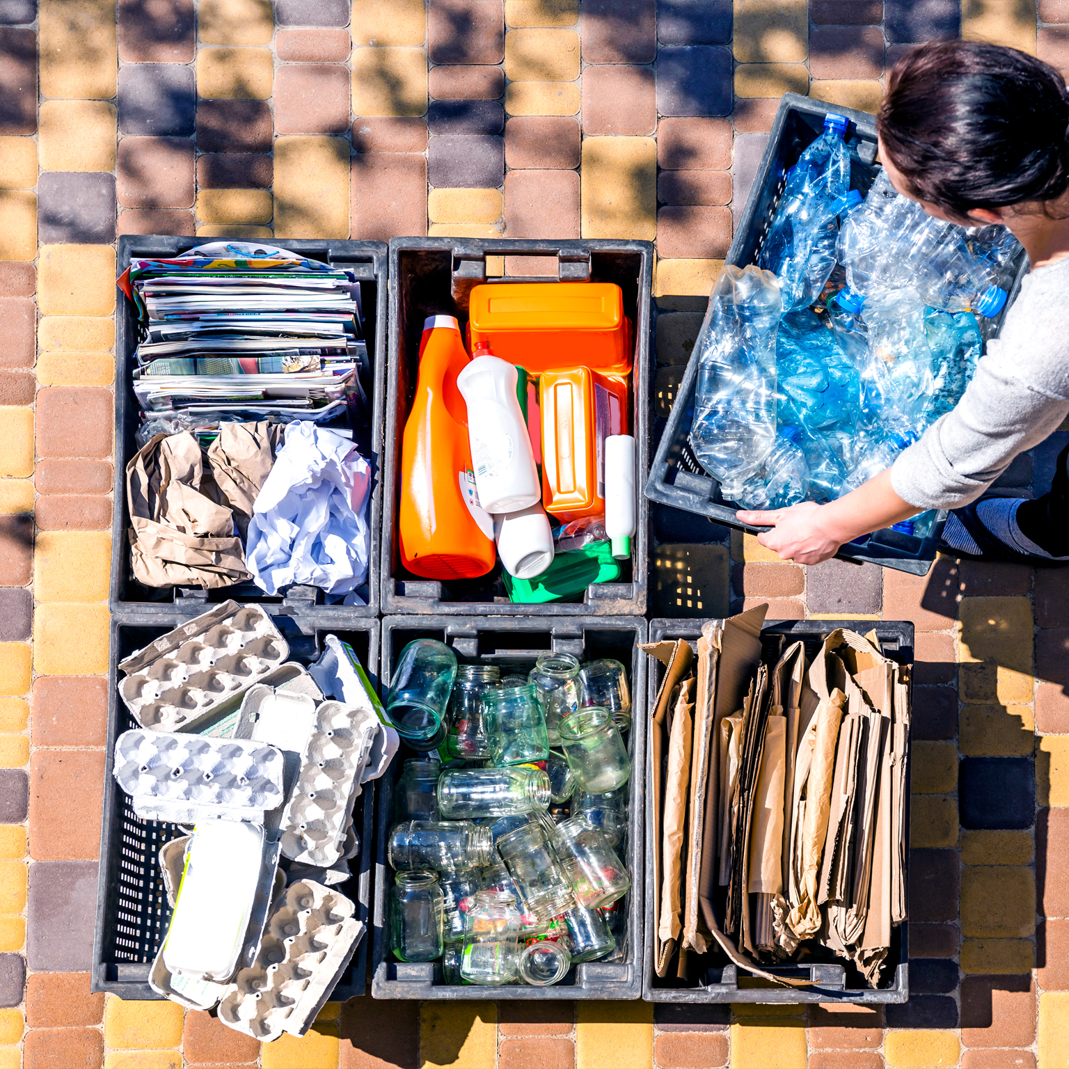 Woman organizes garbage containers for recycling