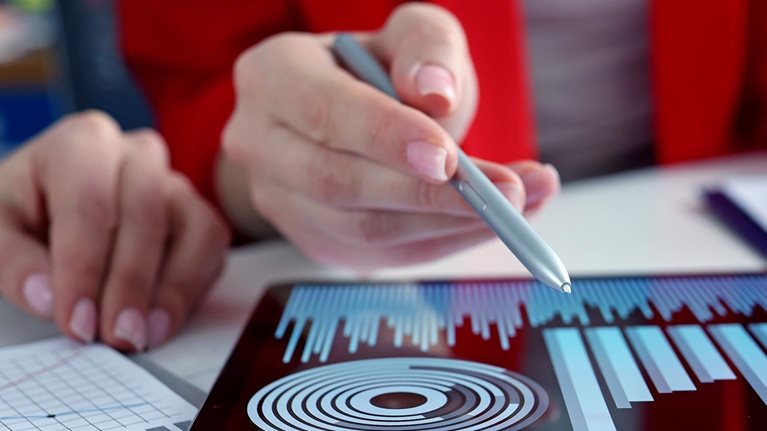 Closeup of business women studying charts and diagrams on a digital tablet