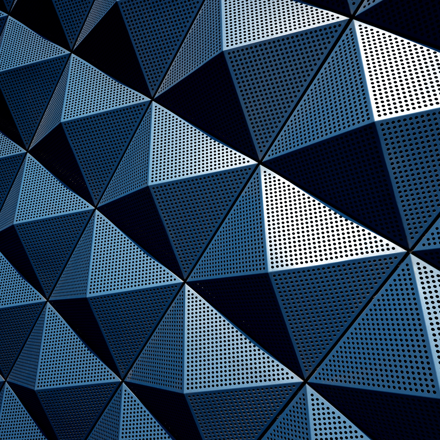 A wall composed of repeating metal pyramids.