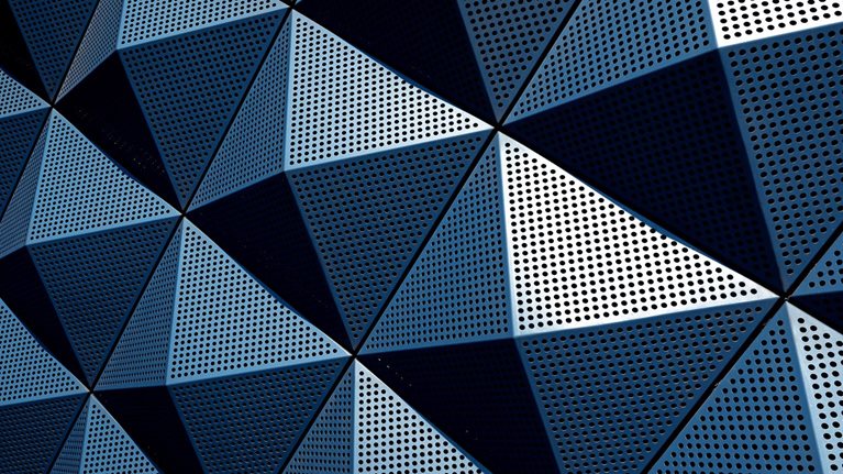 A wall composed of repeating metal pyramids.