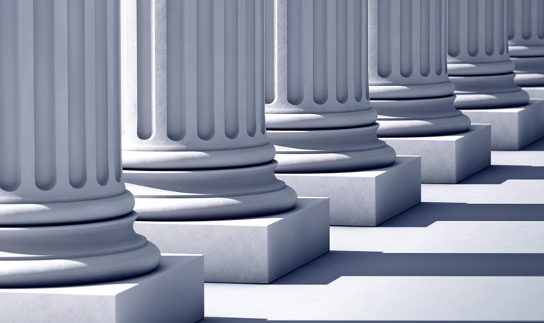 A deep row of stone columns casting long, linear shadows.