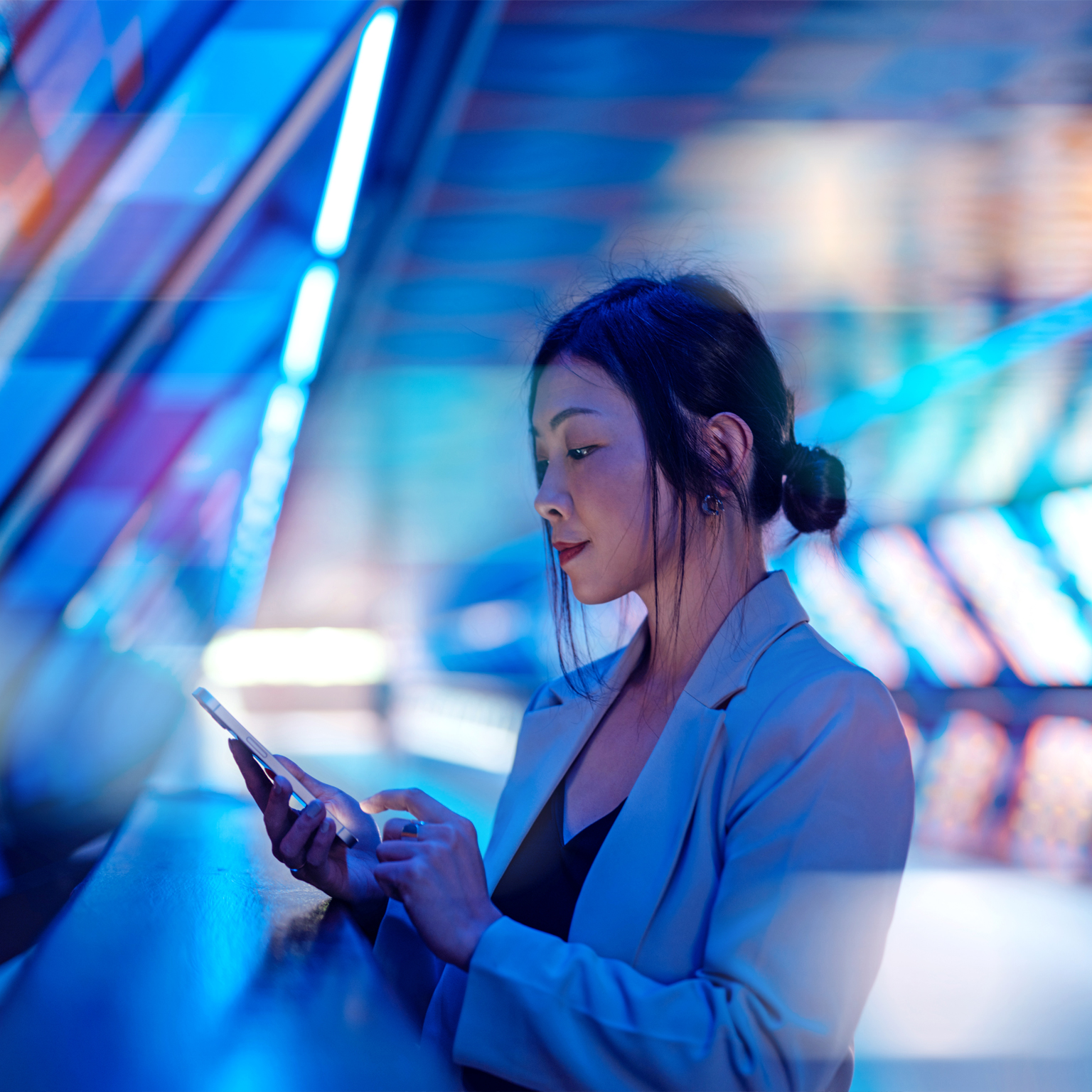 Young Asian business woman using smart phone in a Virtual Reality (VR) environment