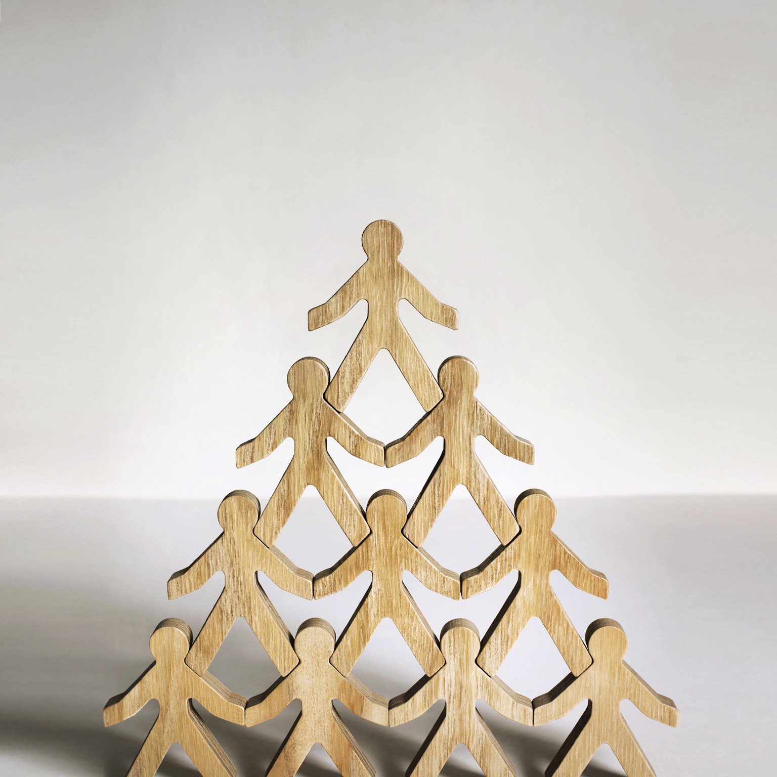 Wooden stick figures stacked in a pyramid.