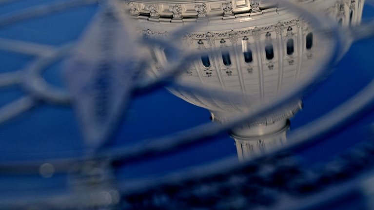 Close-up of the compass in the courtyard of the the U.S. Capitol Building with the domed top of the Capitol Building reflected in it.
