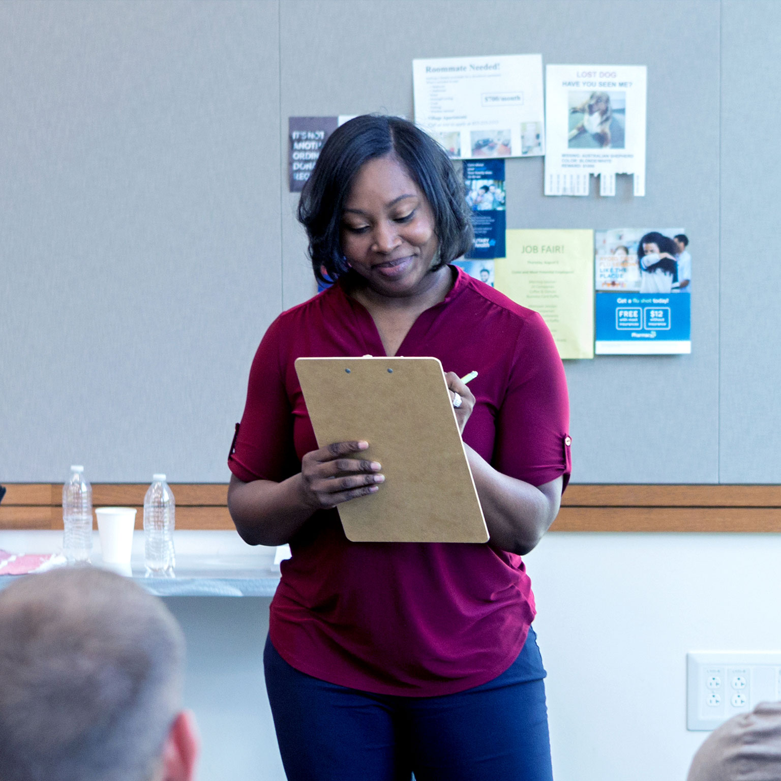 Confident mid adult woman takes attendance during a community group event. - stock photo