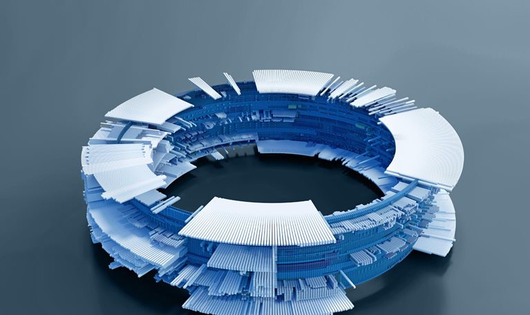 A circular structure composed of numerous small, rectangular blocks in shades of blue and white. The structure resembles a complex, futuristic computer component, with layers of blocks creating an intricate design.