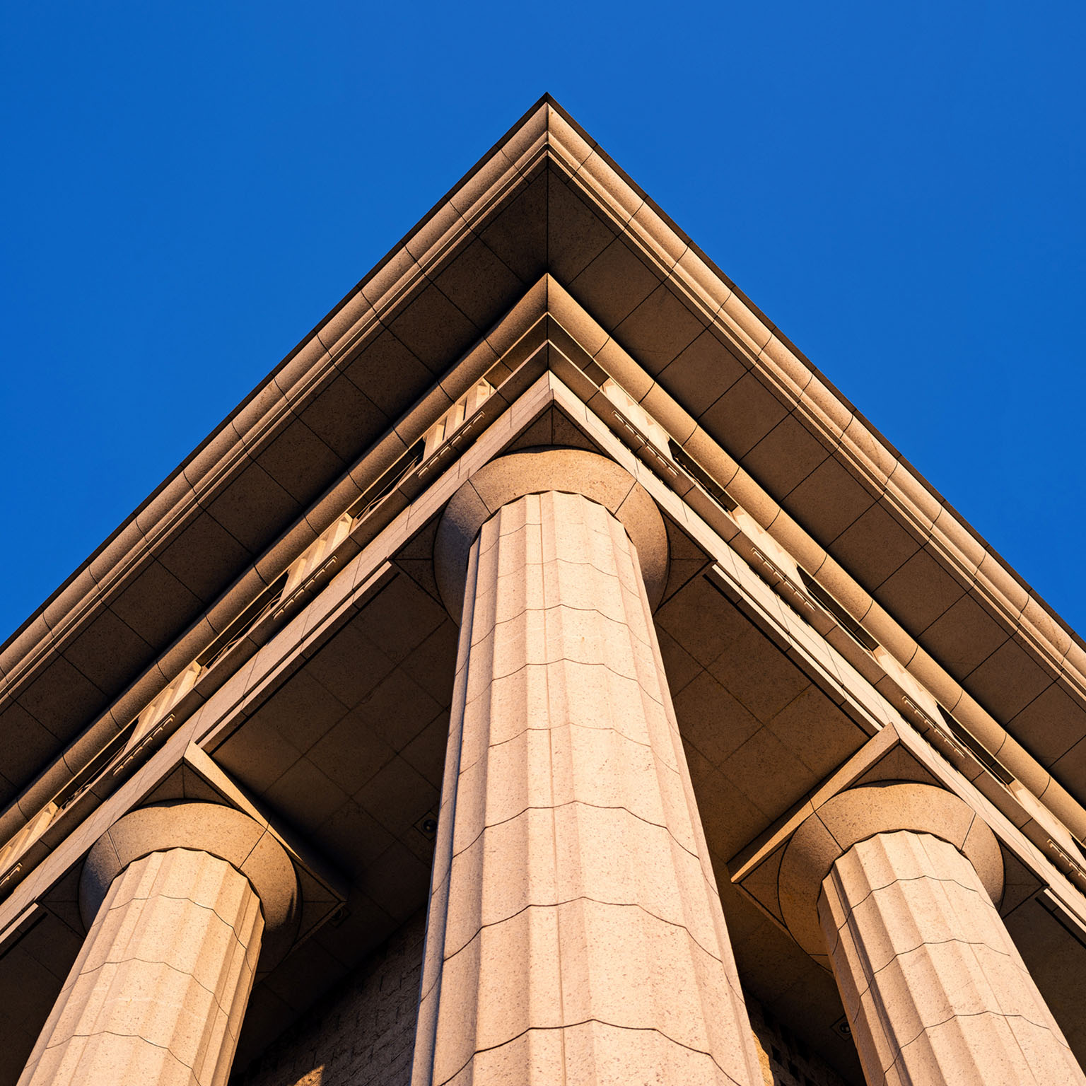 The exterior of a government building with large columns supporting the roof. The building is made of stone and has a classical architectural style.