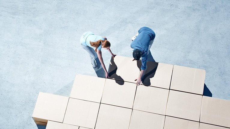 Couple building house outline on sidewalk - stock photo